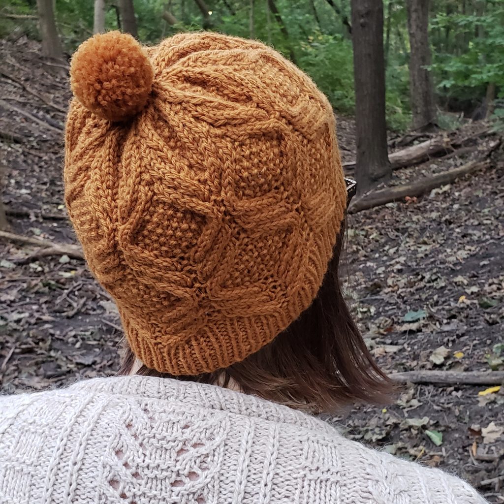 A woman wearing a yellow cabled toque.
