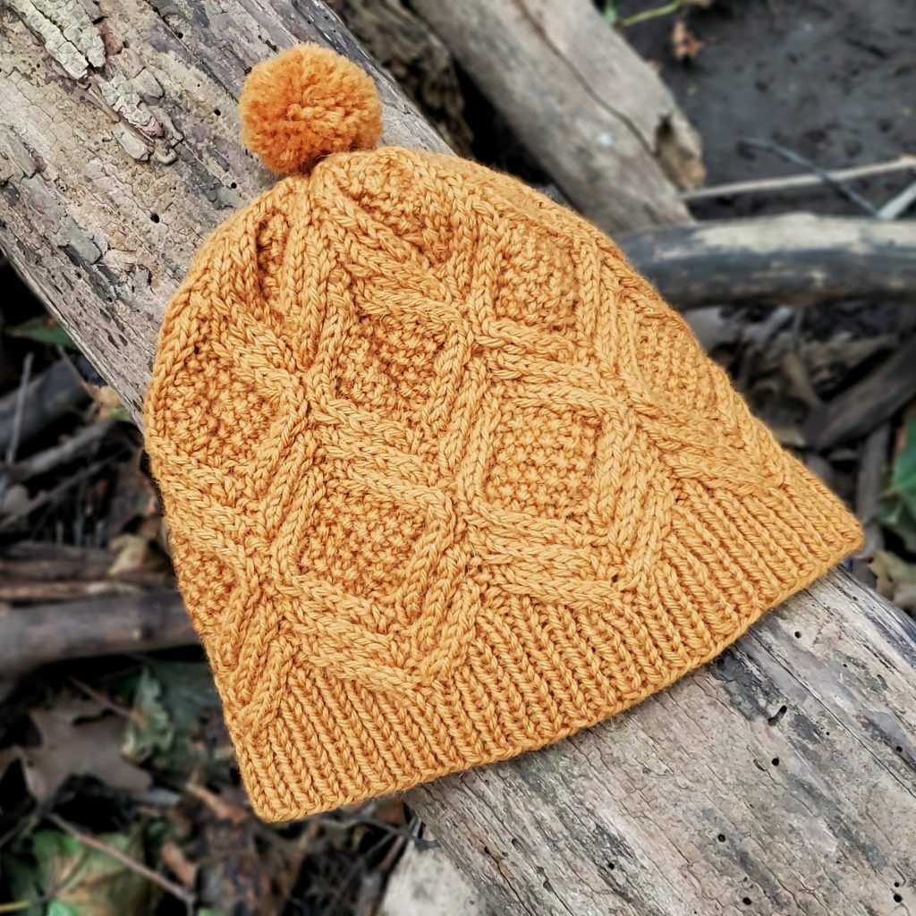 A marigold-coloured yellow version of the cabled hat.