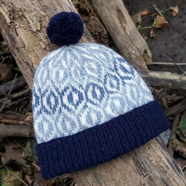 A toque in shades of blue and white with a geometric design.