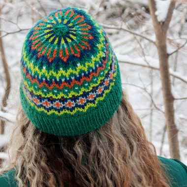 Picture of a woman wearing a tranded colourwork hat.